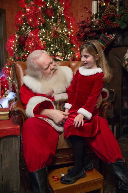 Carl Anderson listens to a child while sitting in his great big chair in NorthPark Center Mall