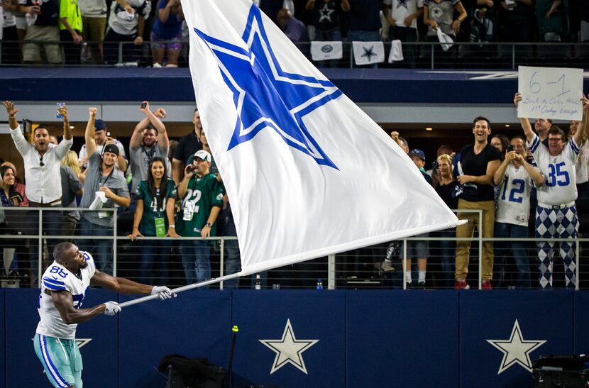 Dallas Cowboys wide receiver Dez Bryant waves a flag in celebration after the Cowboys 29-23...