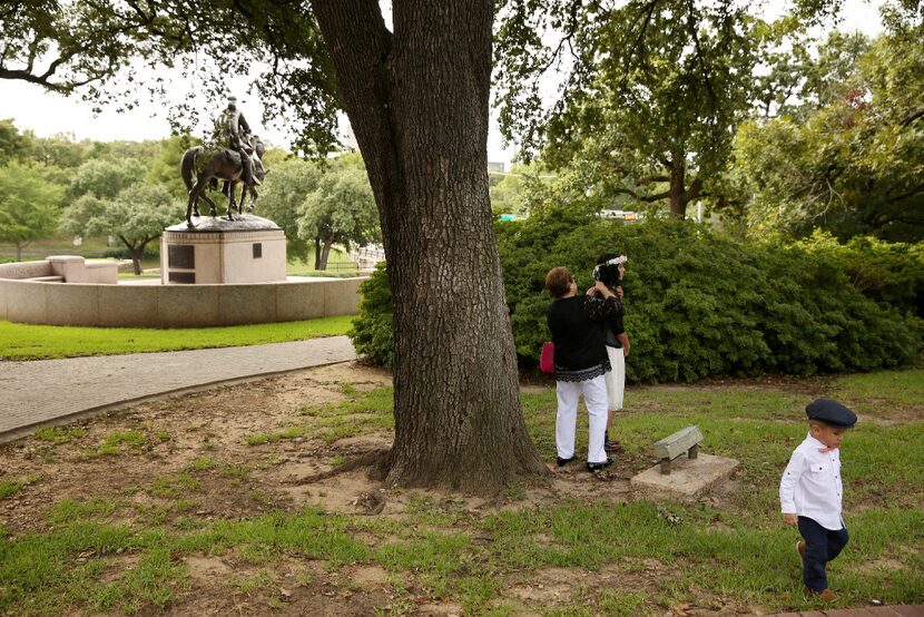 Matthew Chavez, 2, walks by as his mother, Miranda Taddei (in floral headwear), is readied...