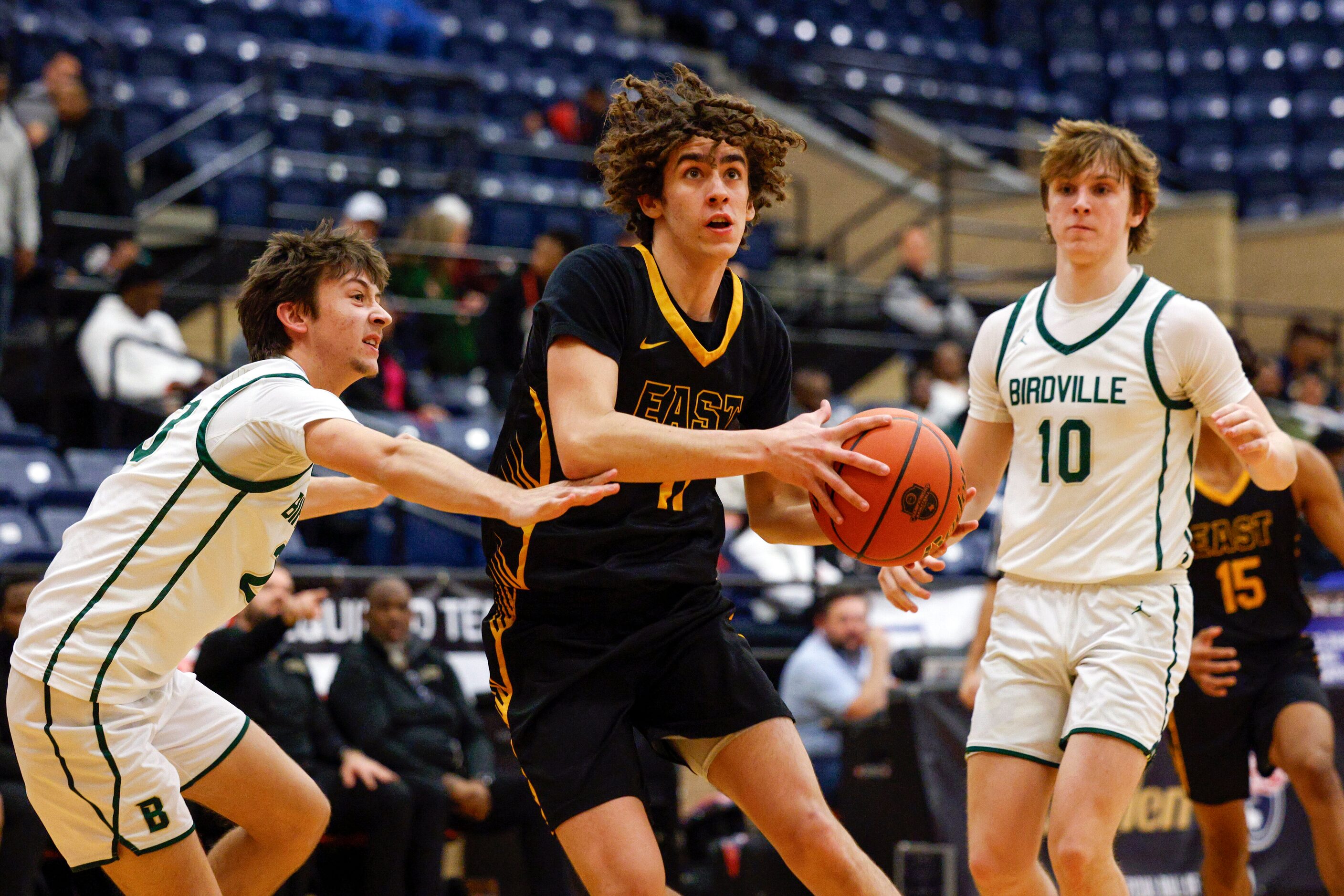 Plano East wing Carter Buchanan (11) drives past Birdville guard Parker Hester (left) during...