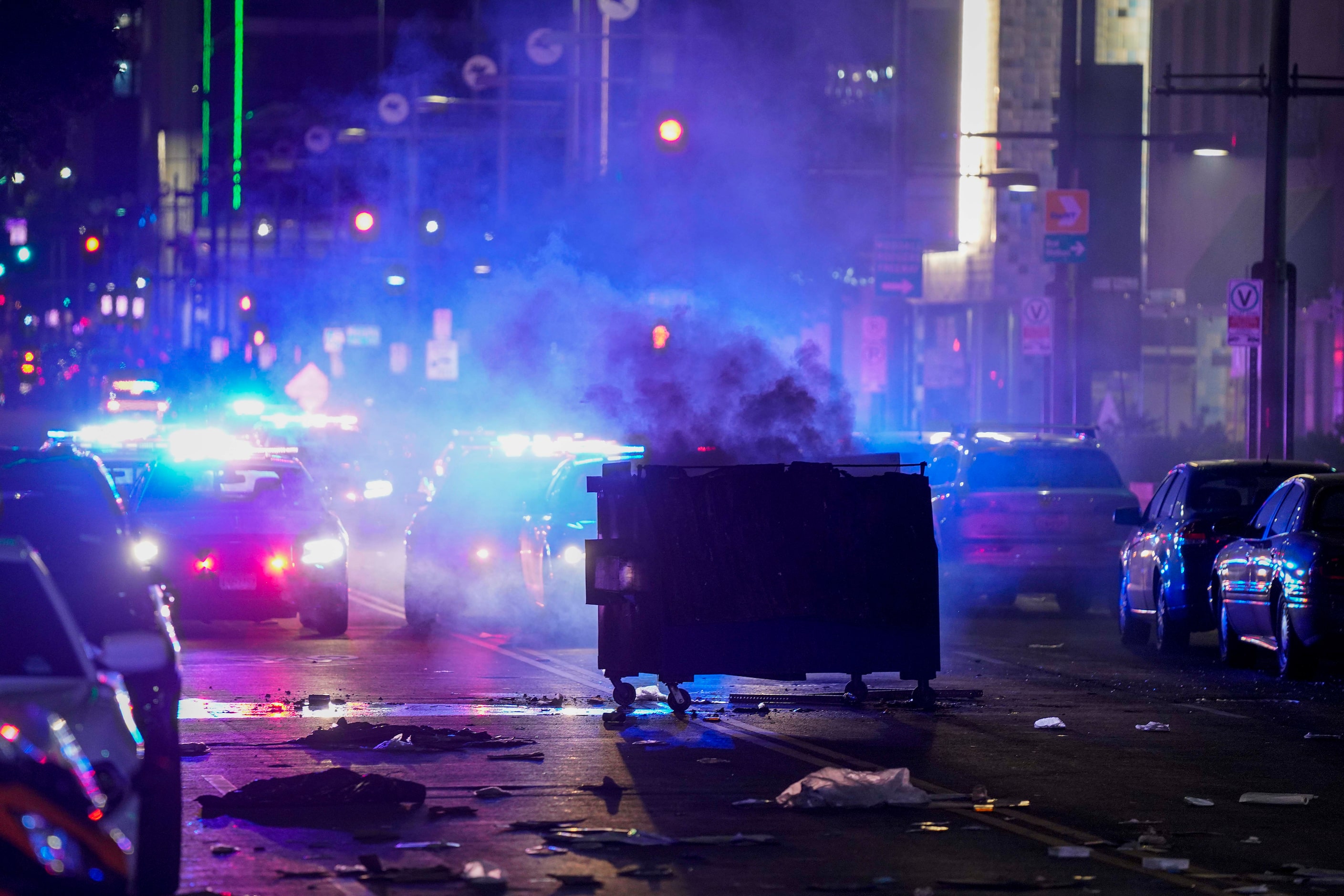 A dumpster smolders as debris covers the middle of Main Street downtown following a protest...