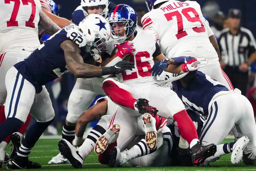 New York Giants running back Saquon Barkley (26) is dropped for a loss by Dallas Cowboys...