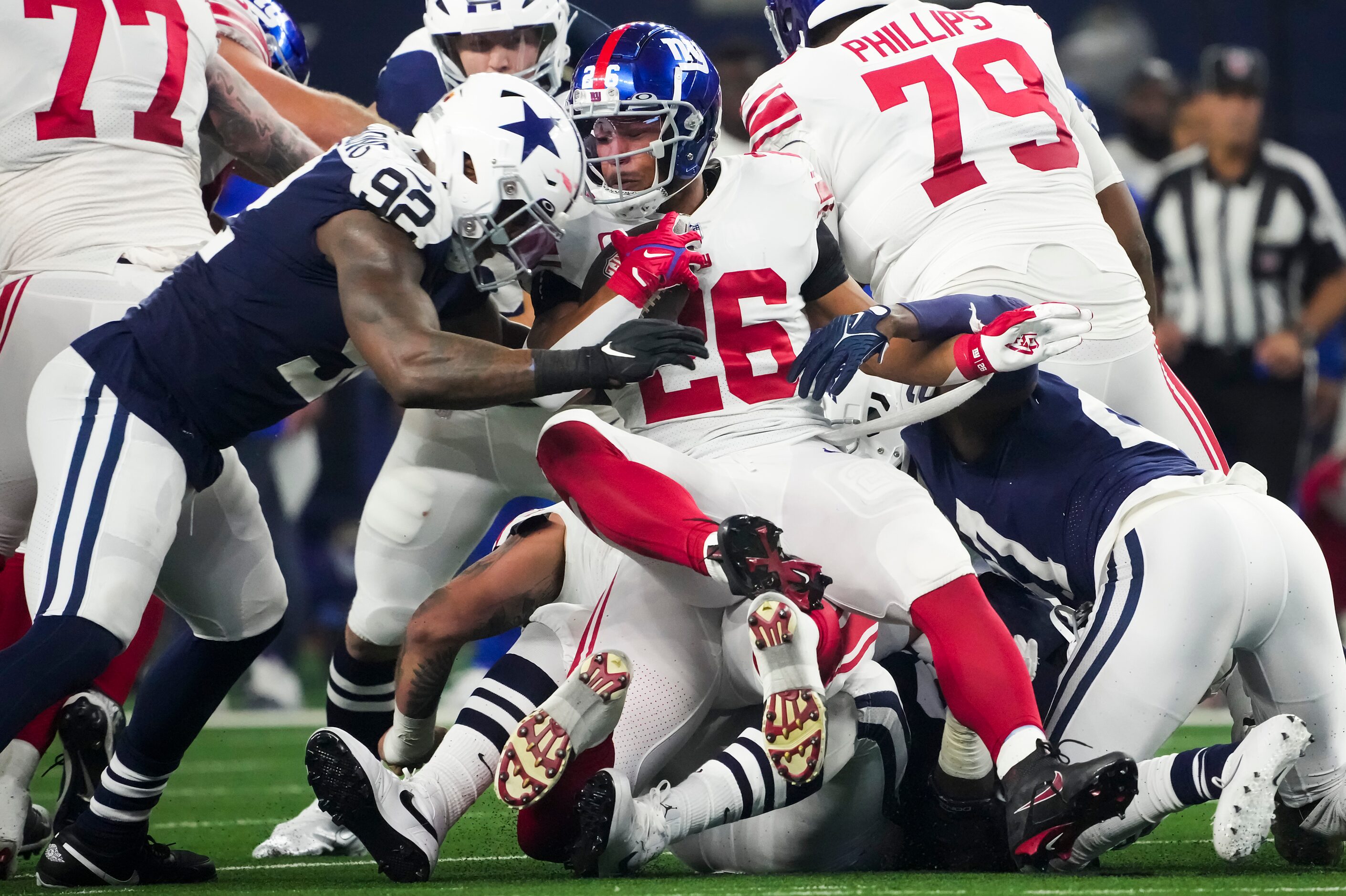 New York Giants running back Saquon Barkley (26) is dropped for a loss by Dallas Cowboys...