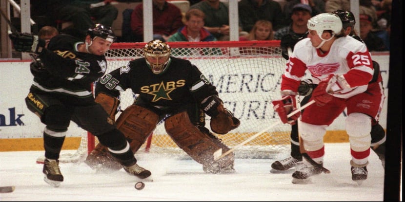Dallas Stars goalie Andy Moog (35) watches as teammate  Paul Cavallini (14) and Detroit Red...