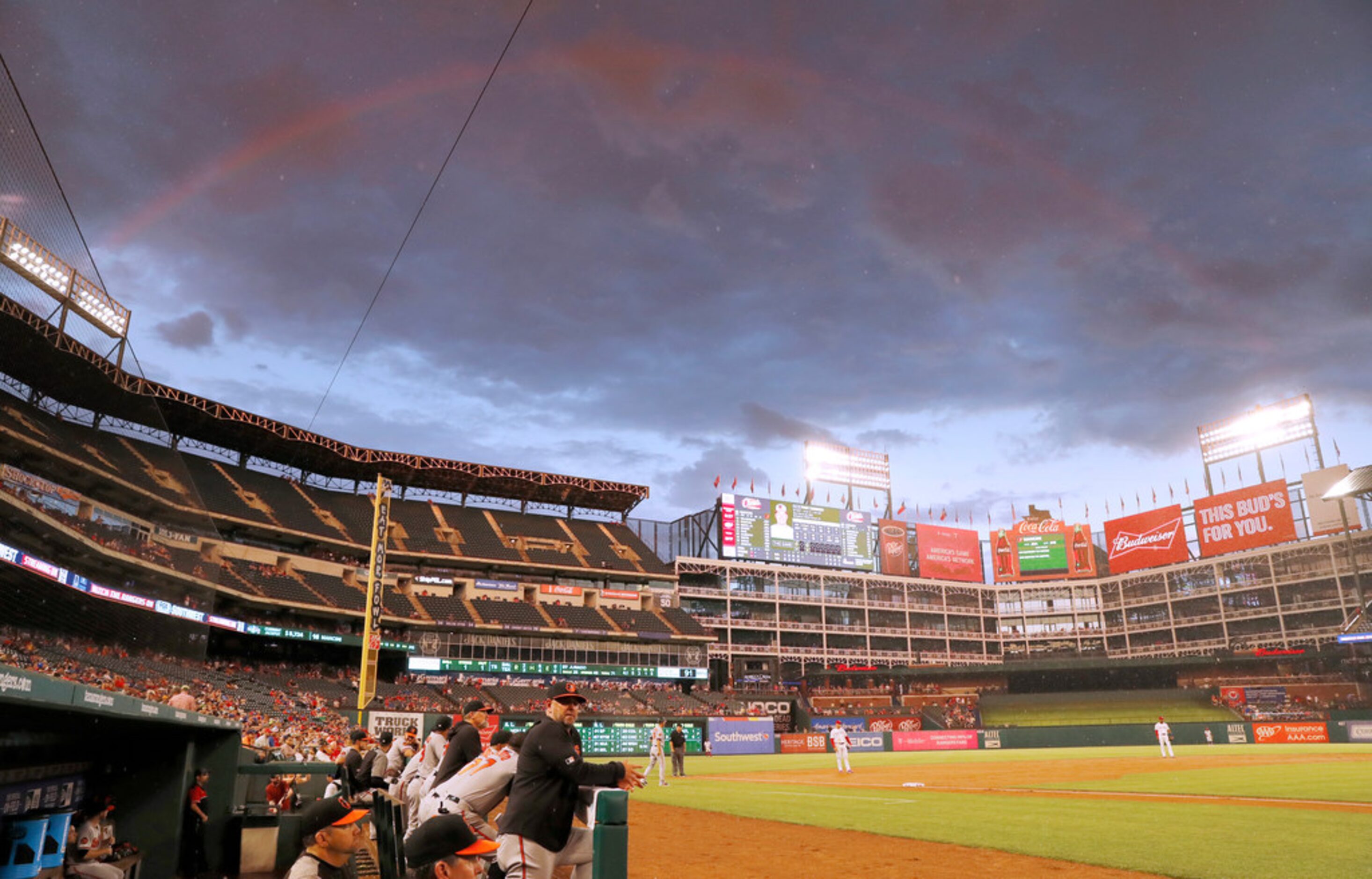 A faint rainbow lines the sky over Globe Life Park after a short but heavy rainfall during a...