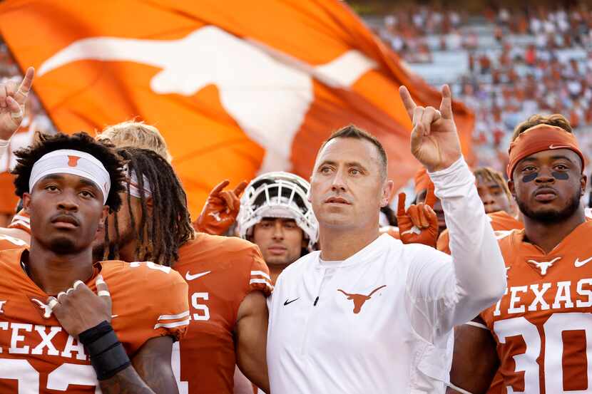 Texas Longhorns head coach Steve Sarkisian (center) and his players sing 'The Eyes of Texas'...