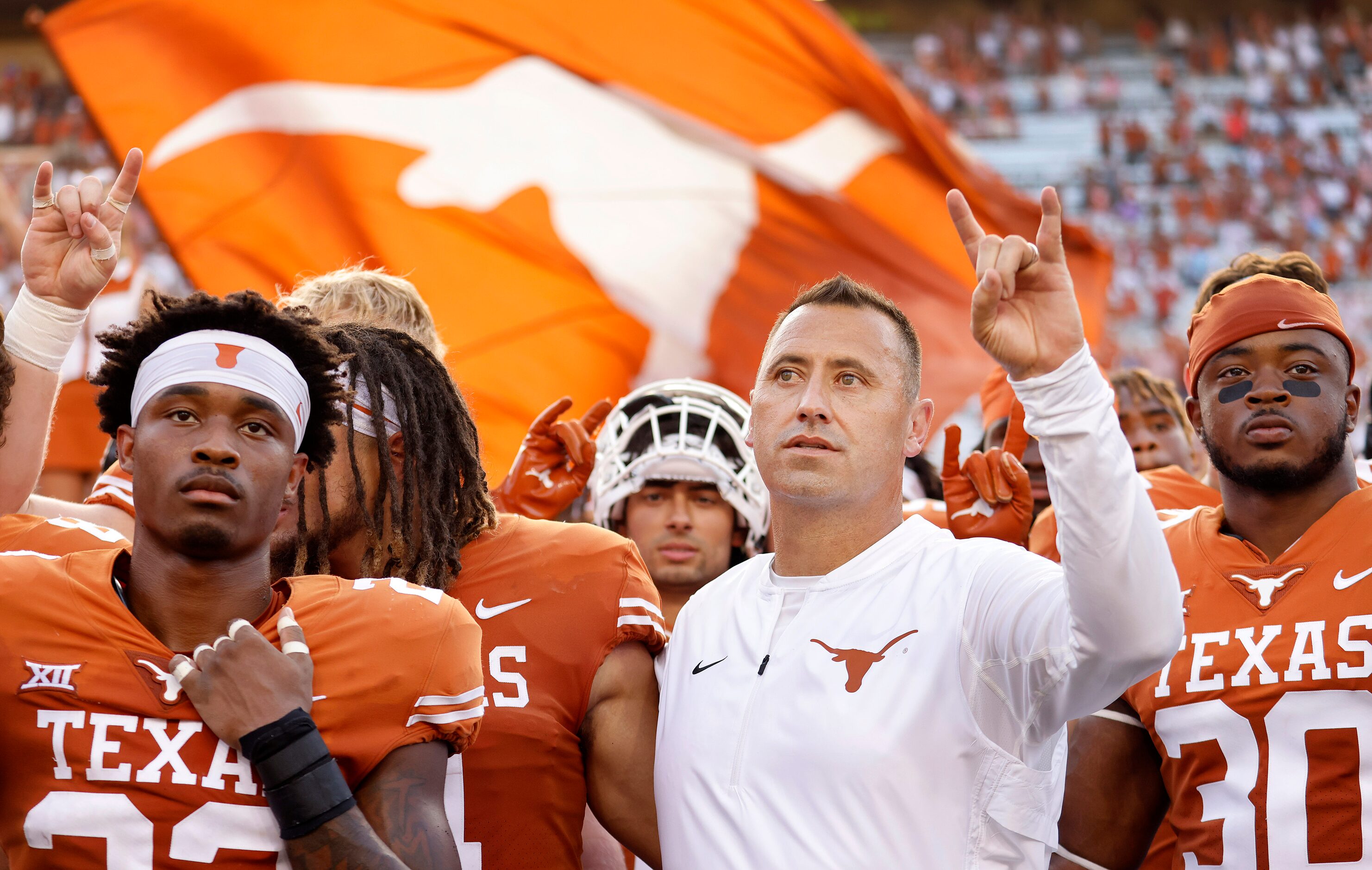 Texas Longhorns head coach Steve Sarkisian (center) and his players sing 'The Eyes of Texas'...