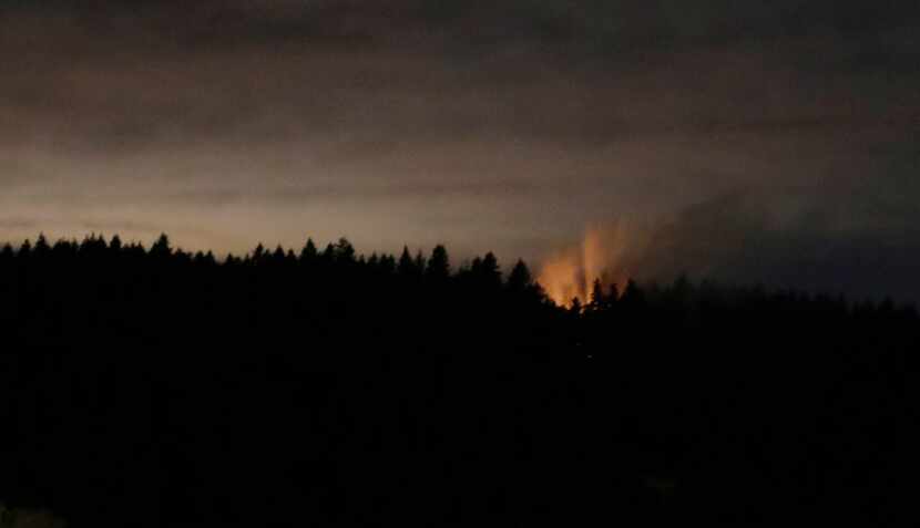 In this long-exposure photo, smoke and an orange glow are seen on Ketron Island in...