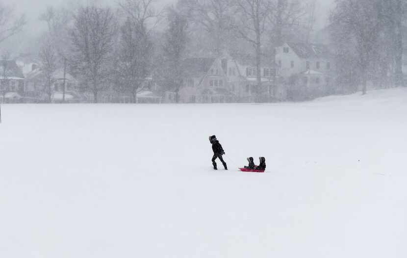  A woman pulls her kids on a sled through Havemeyer Fields in Greenwich, Connecticut January...