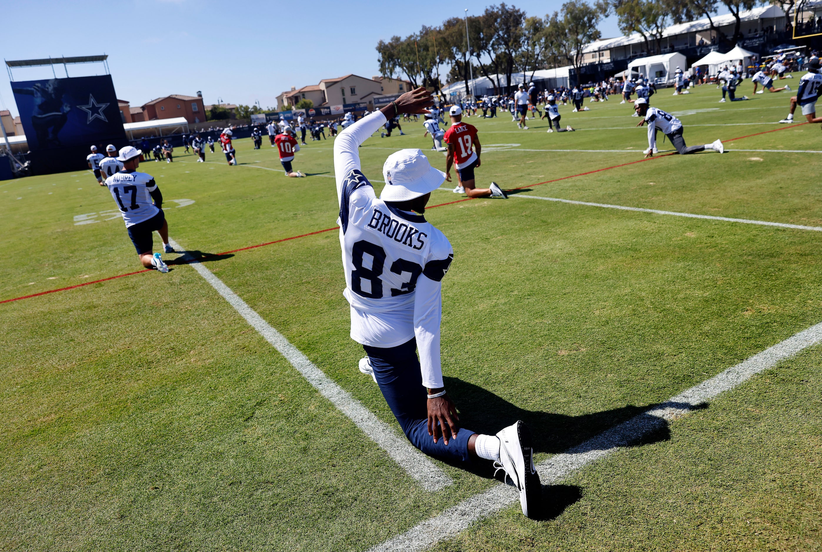 Dallas Cowboys wide receiver Jalen Brooks (83) and the rest of the team stretch during a...