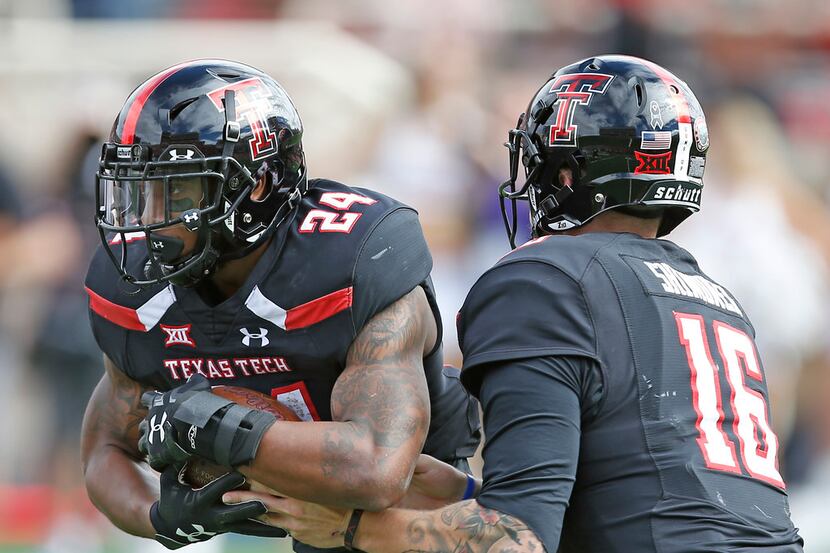 Texas Tech's Nic Shimonek (16) hands the ball off to Tre King (24)  during an NCAA college...