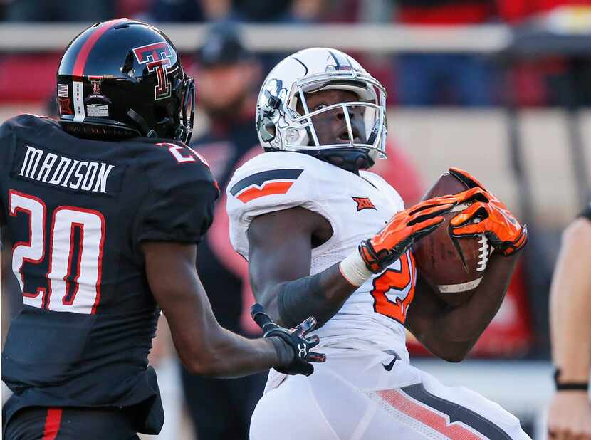 Oklahoma State wide receiver James Washington right, takes a J.W. Walsh pass into the end...