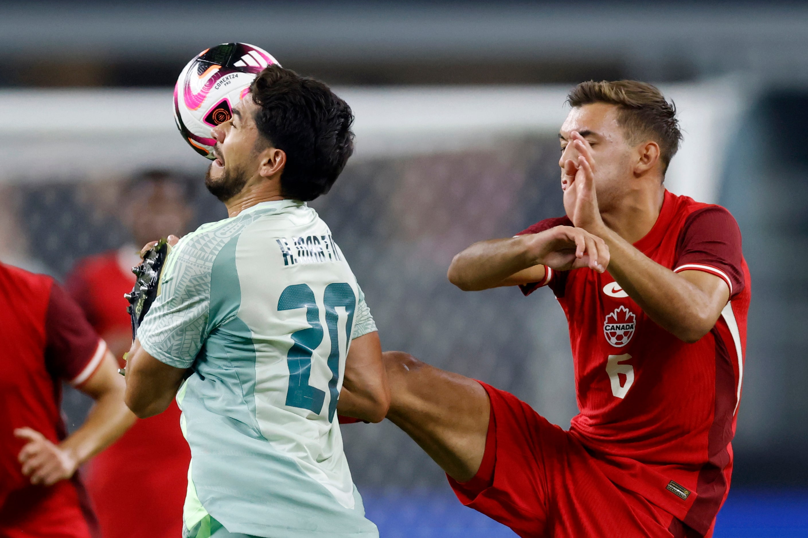 Canada midfielder Niko Sugur (6) kicks the ball near the head of Mexico forward Henry Martin...