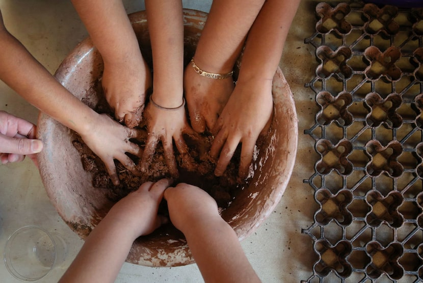 Third-grade students from Uplift Pinnacle Preparatory mix the ingredients to make seed bombs...