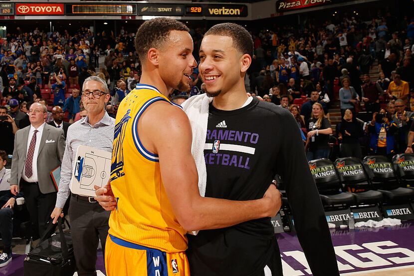 SACRAMENTO, CA - JANUARY 09:  Stephen Curry #30 of the Golden State Warriors hugs Seth Curry...