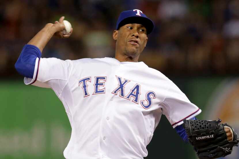 Texas Rangers relief pitcher Alexi Ogando (41) throws against the Seattle Mariners in the...