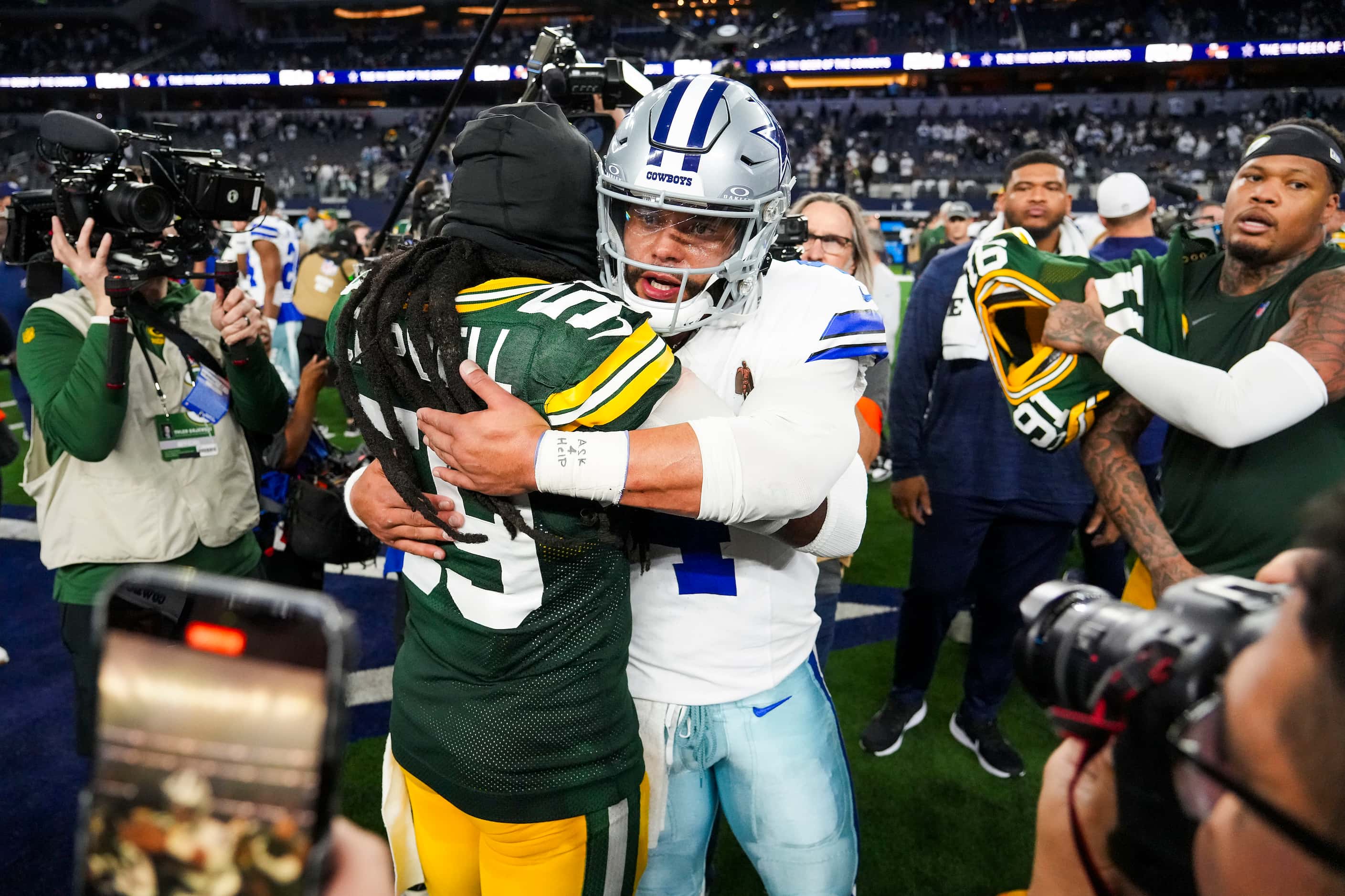 Dallas Cowboys quarterback Dak Prescott (4) hugs Green Bay Packers linebacker De'Vondre...