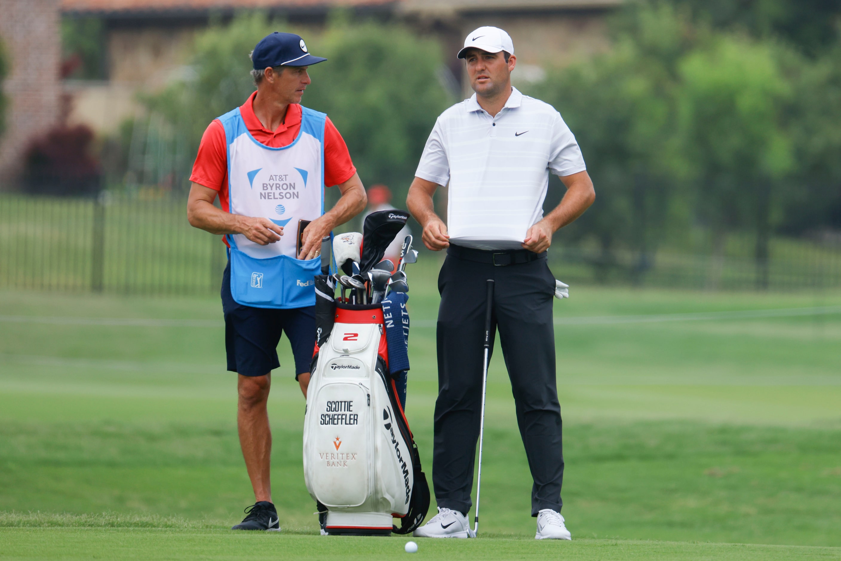 Scottie Scheffler (right) waits to hit on the green of the ninth hole during the second...