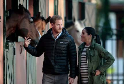 Britain's Prince Harry and Meghan Markle, duchess of Sussex, walk together during a visit to...