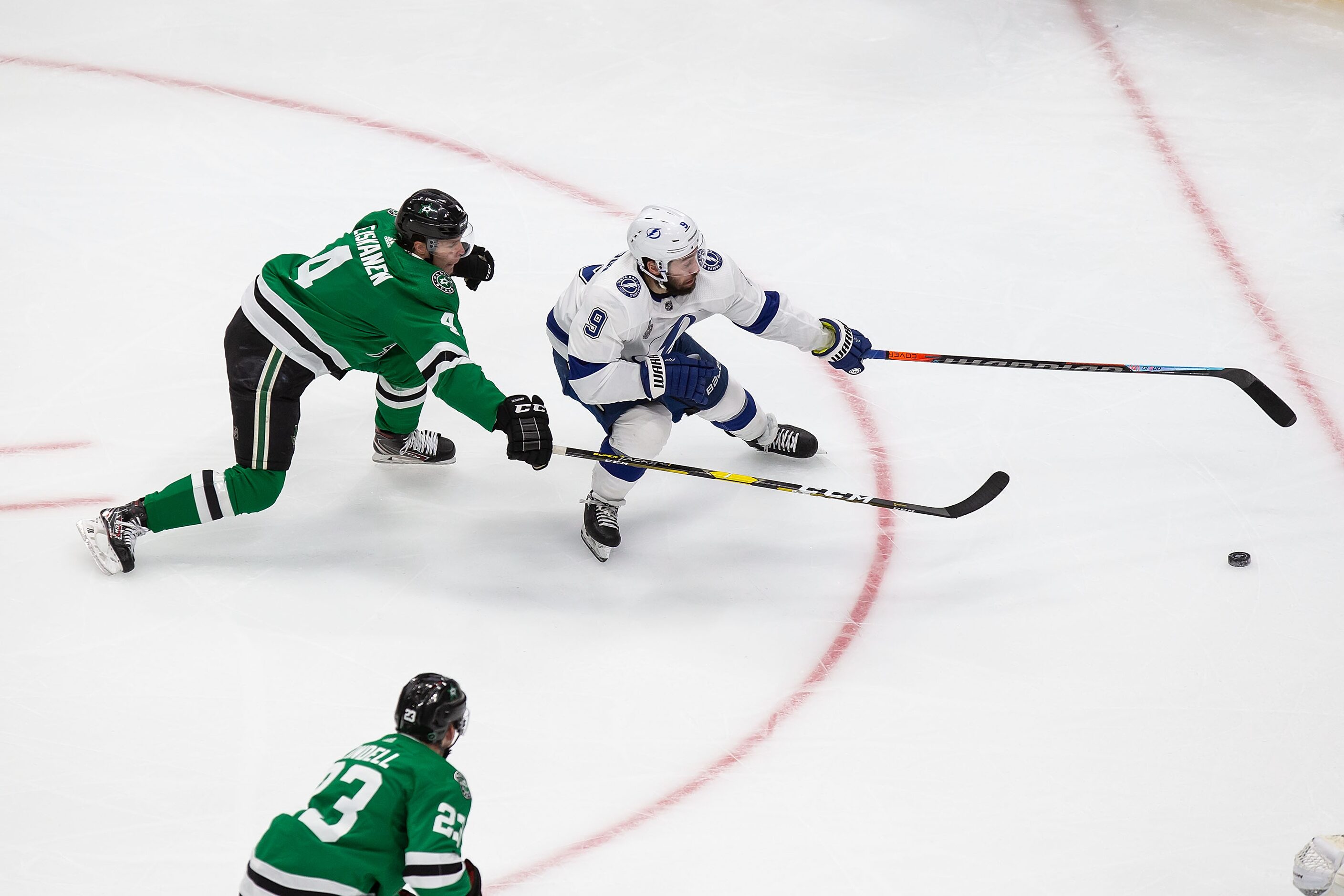 Miro Heiskanen (4) of the Dallas Stars battles against Tyler Johnson (9) of the Tampa Bay...