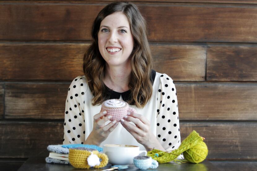 Meredith Crawford poses for a portrait with a latte cup she crocheted at The Pearl Cup...