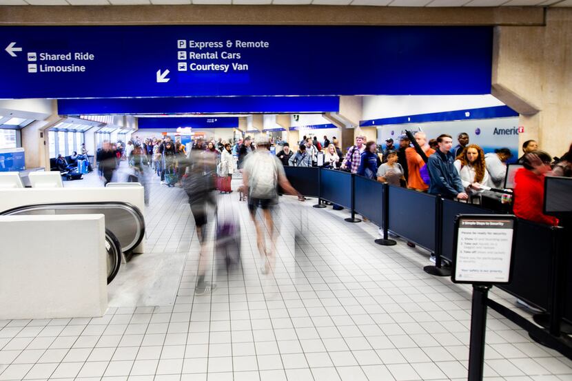 Travelers make their way thought DFW International Airport terminal C security on Friday,...