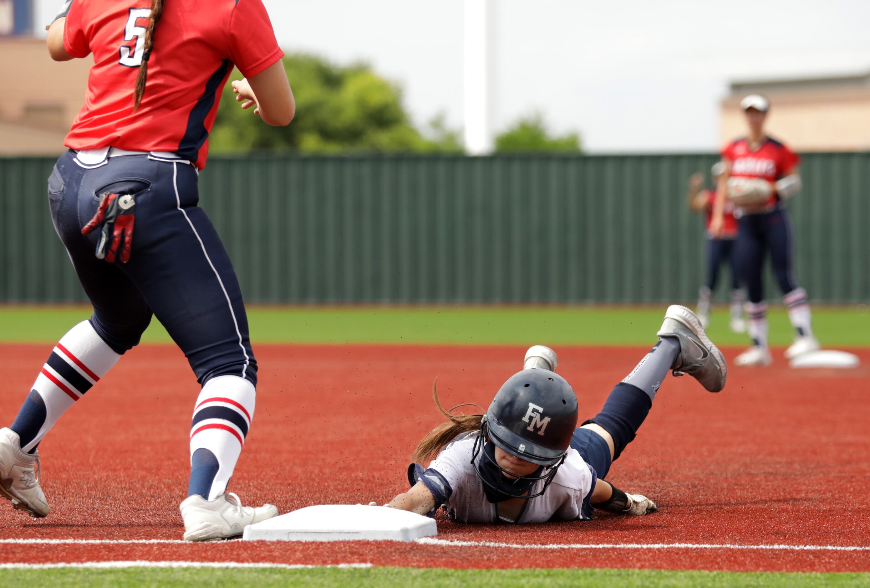 Flower Mound High School player #7, Logan Halleman, slides back into first base as Allen...