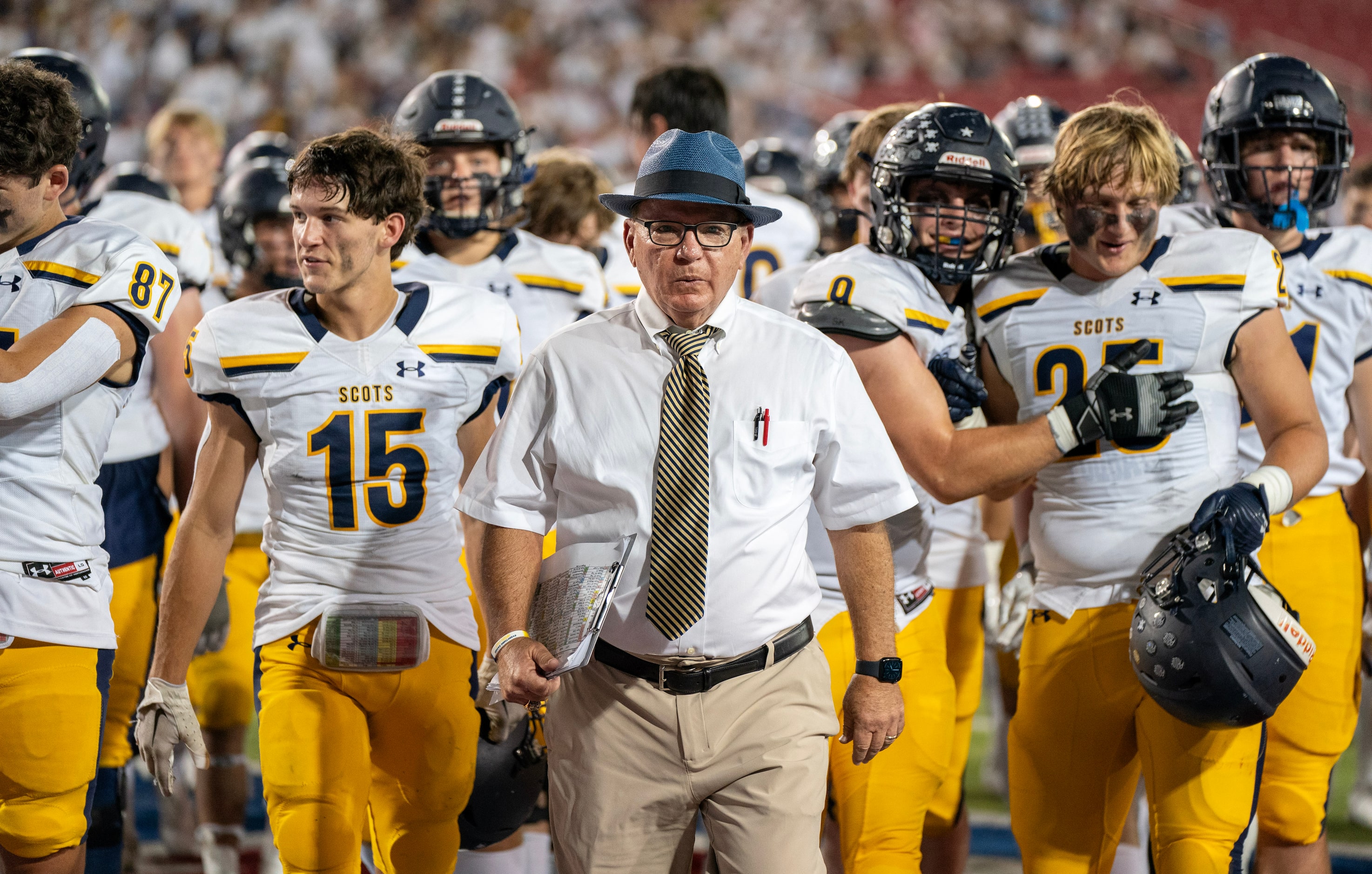 Highland Park head coach Randy Allen leads his team off the field during halftime of a high...