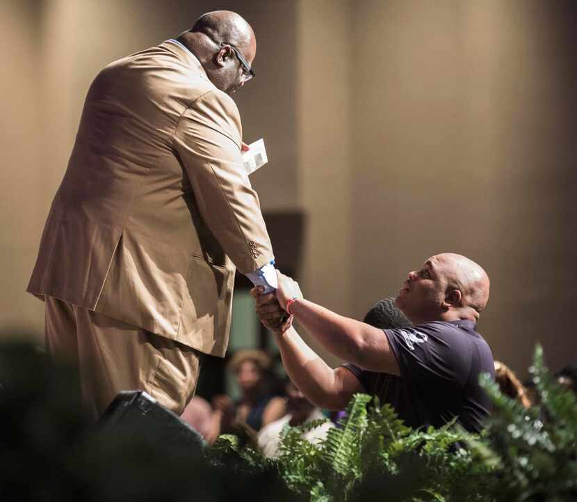 Adrian Taylor,  brother of Christian Taylor, holds the hand of Dwight McKissic Sr., senior...