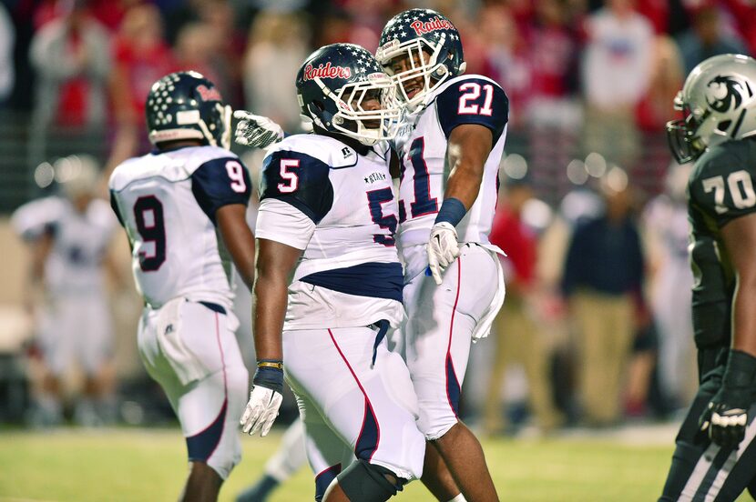 Ryan senior defensive tackle Ken McLaurin (5) and junior linebacker Tyreke Davis (21)...