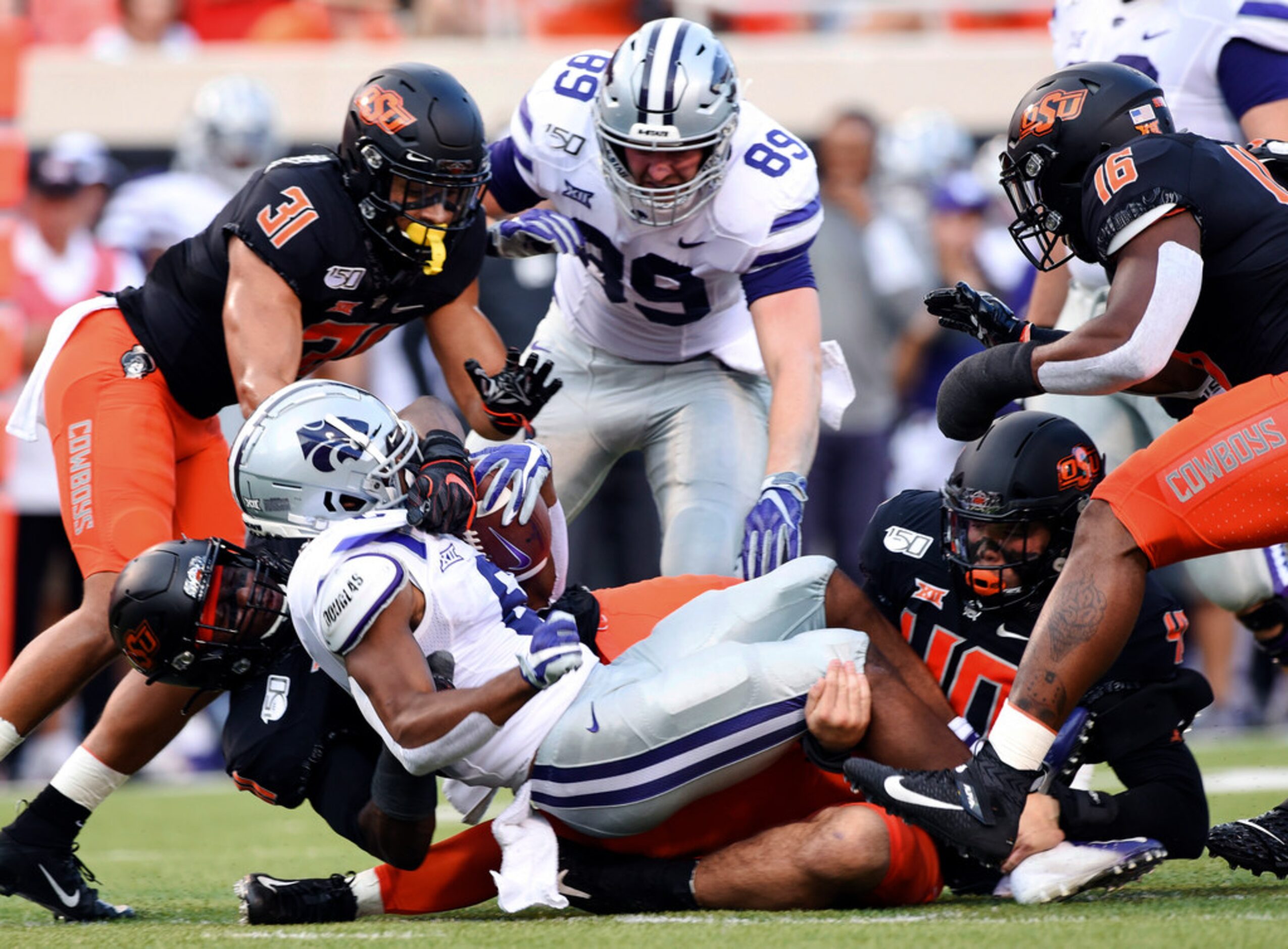 Oklahoma State safety Kolby Harvell-Peek (31), Kansas State tight end Blaise Gammon (89) and...