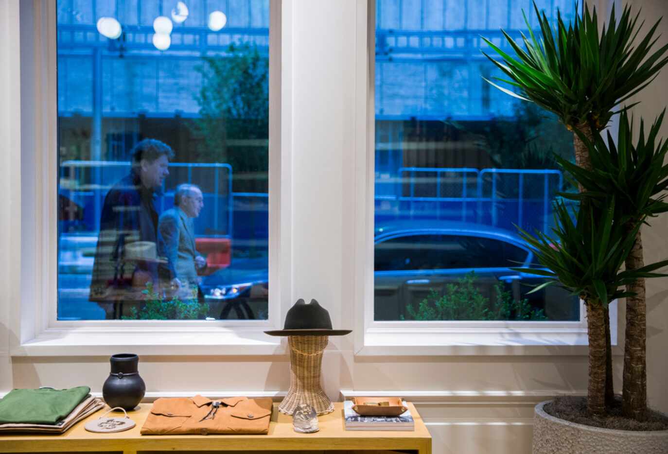 Two men walk past the front window at Common Goods + Supply inside the newly renovated...