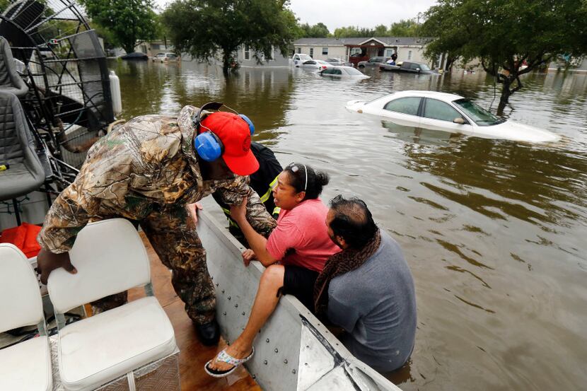 Gulf Coast Rescue Squad air boat driver Felton Jones pulls LaJuana Cisneros into a boat with...