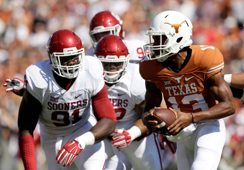 Texas quarterback Jerrod Heard (13) scrambles out of the pocket under pressure from Oklahoma...