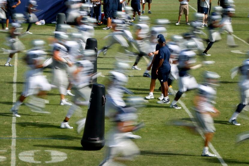 Dallas Cowboys players are a blur as they run down the field during afternoon practice at...