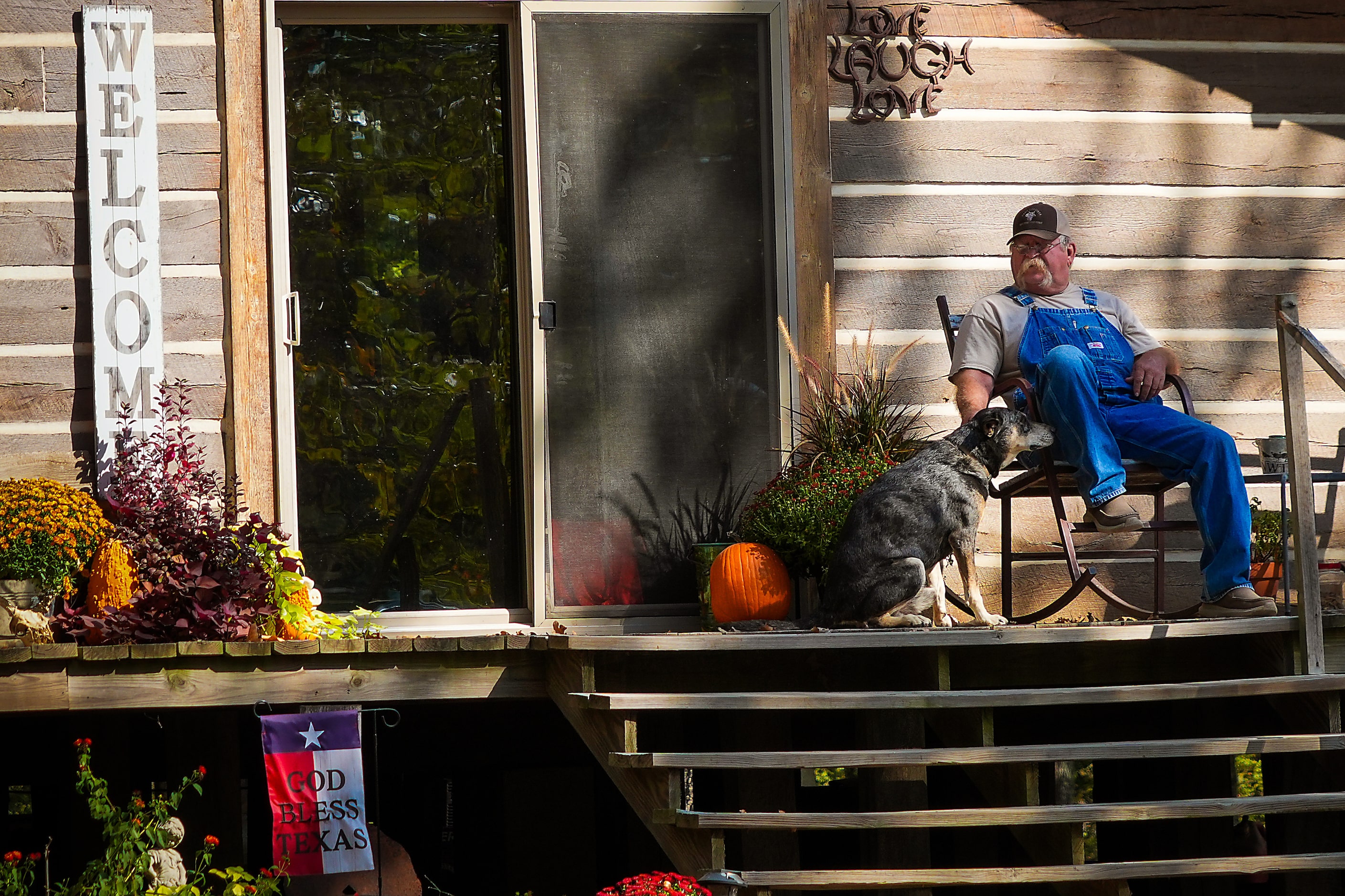 Eddie Belcher, 63, looks out from the porch of the home he built on land in Red River County...