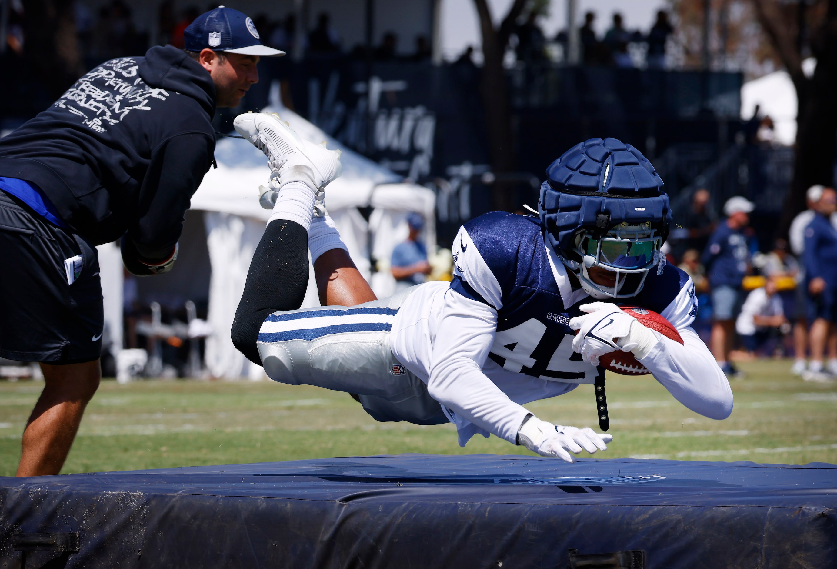 Dallas Cowboys linebacker Damien Wilson (45) dives onto a pad after taking boxing shots to...