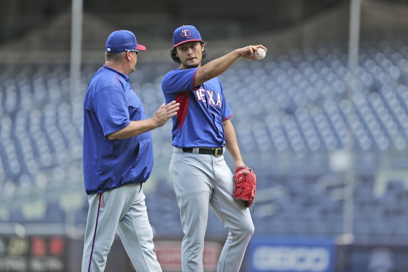 Texas Rangers' pitcher Yu Darvish, right, talks with a coach during a simulated game at...
