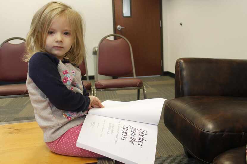 
Sarah Robinson, Michelle’s daughter, flips through the Shelter from the Storm workbook. She...
