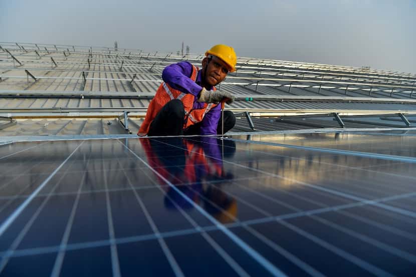 In this photograph taken on May 16, 2017, an Indian labourer installs solar panels at a site...