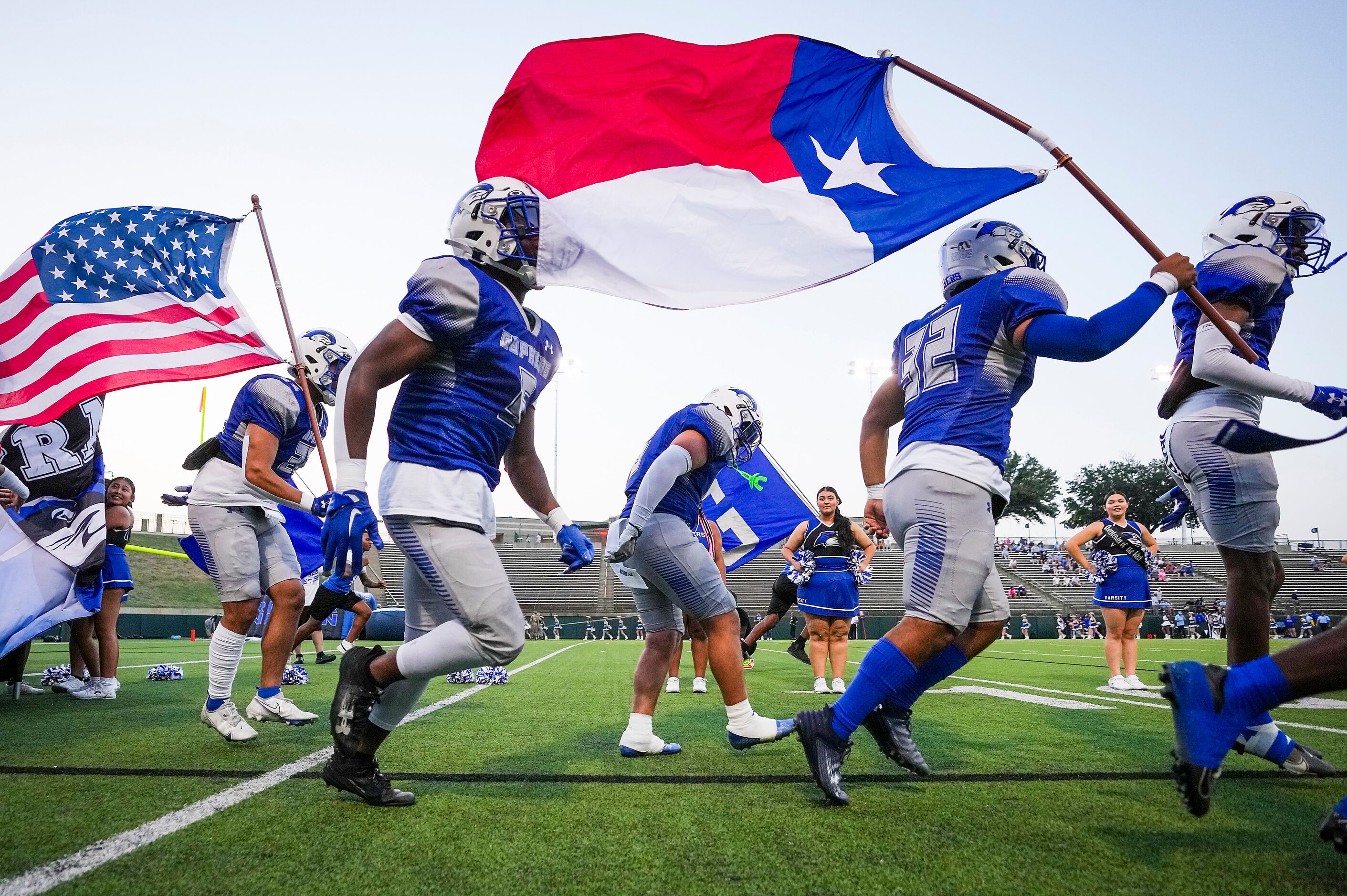 Grand Prairie running back David Rodriguez (32) carries the Texas flag as running back...