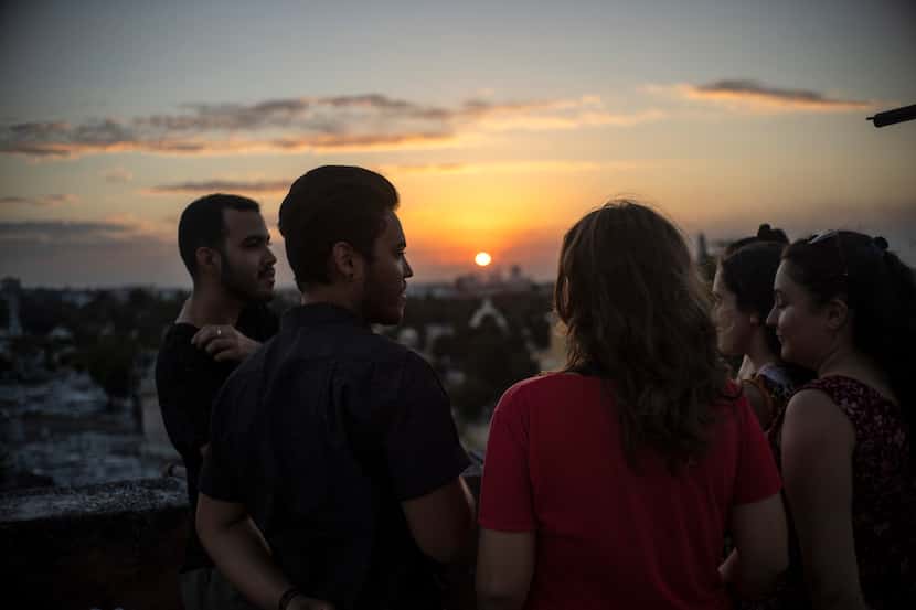 Marcos Marzo, second left, talks with his friends who came to say goodbye upon receiving the...