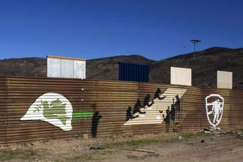 A mural painted by members of the Mural Brotherhood Organization is seen on the border...