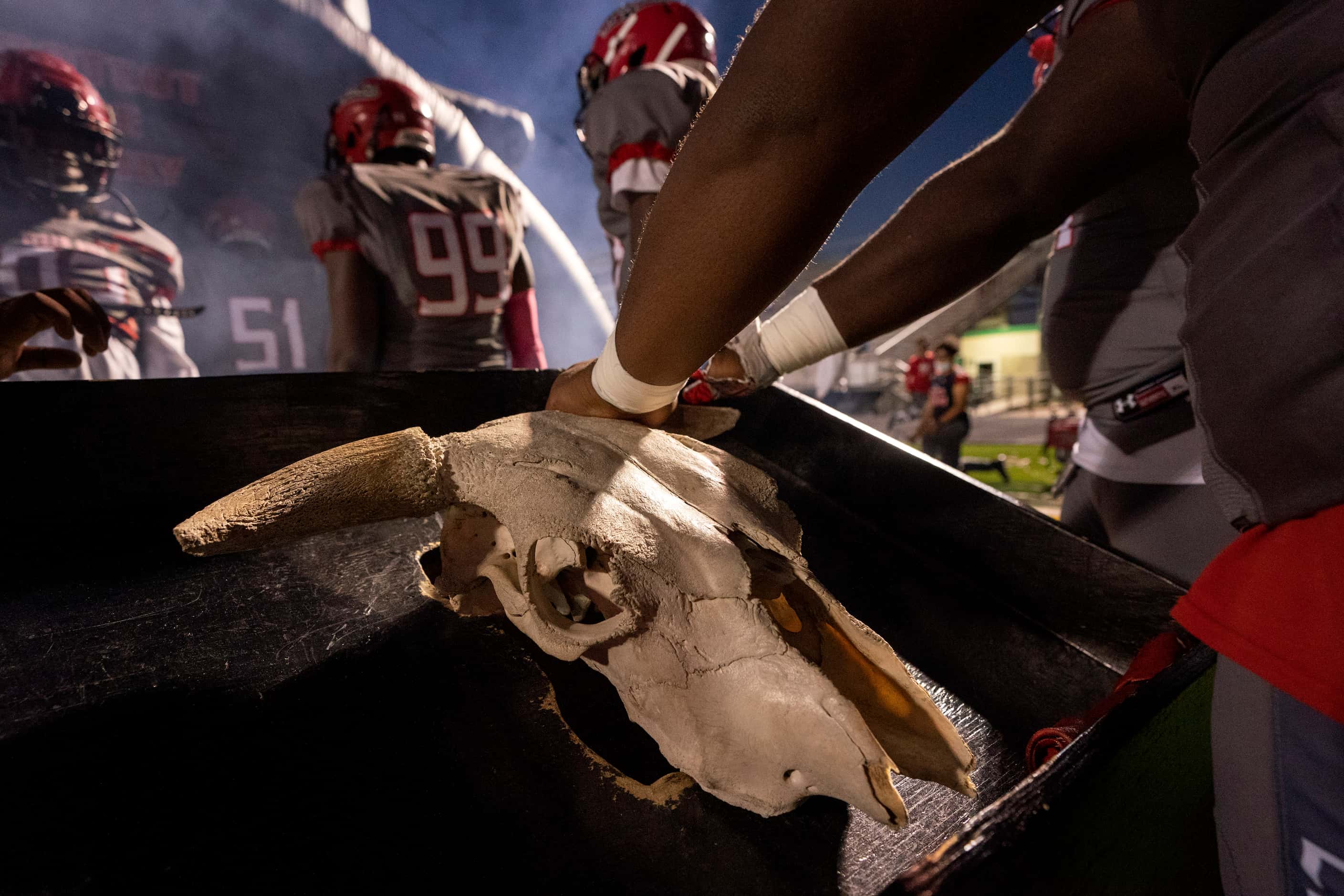 Cedar Hill players touch a longhorn skull before taking the field for a high school football...