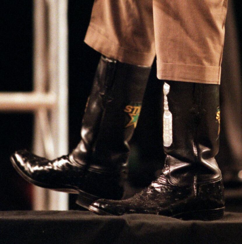 Tom Hicks displays his Stanley Cup cowboys boots to the crowd at Reunion Arena celebrating...