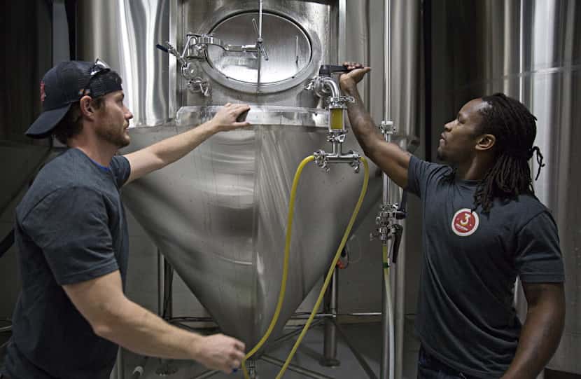 Gavin Secchi (left) and Steven Aikens prepare to fill kegs at 3 Nations Brewing.
