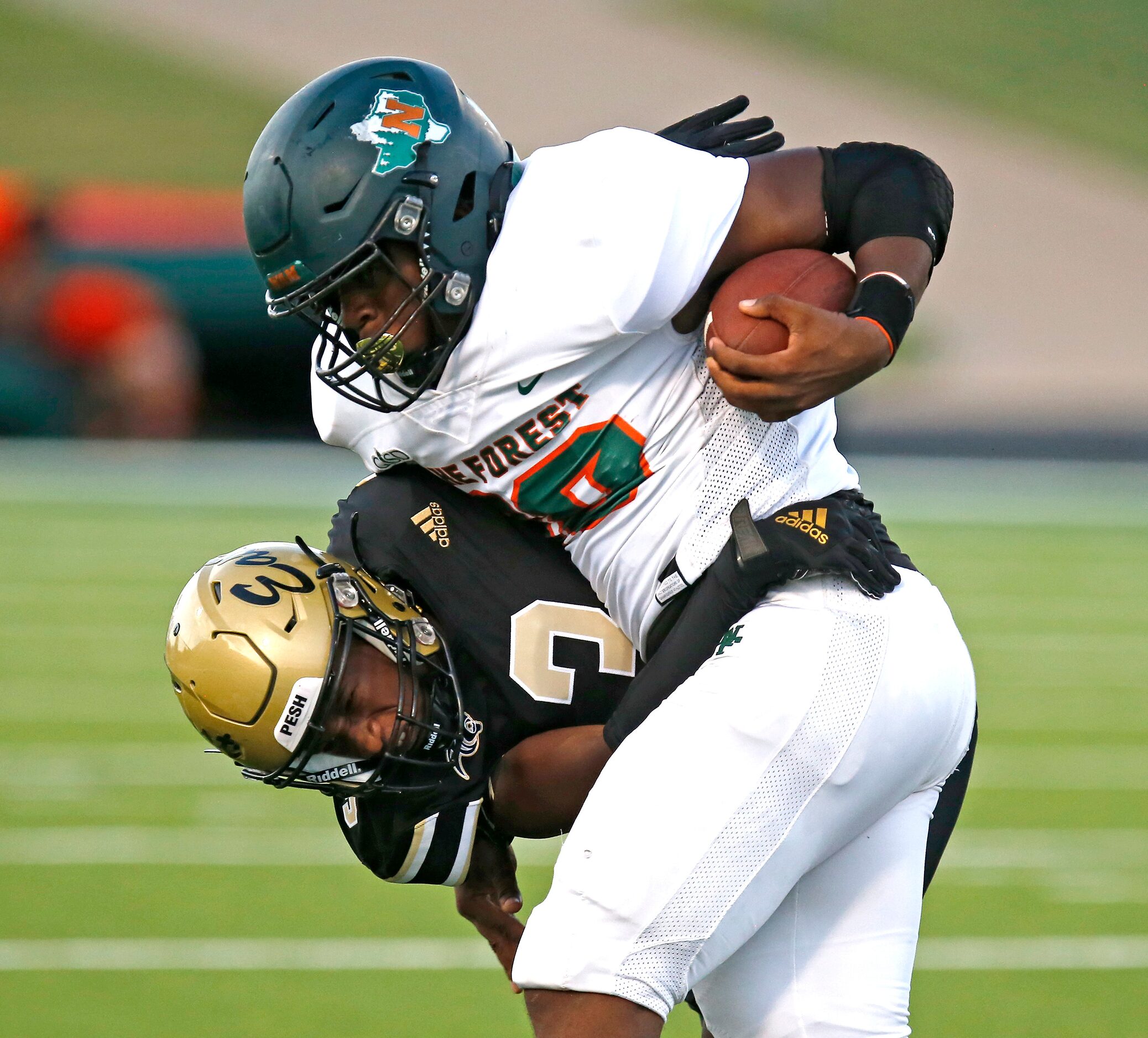 Plano East Senior High School cornerback Adetoye Adesola (3) collides with Naaman Forrest...