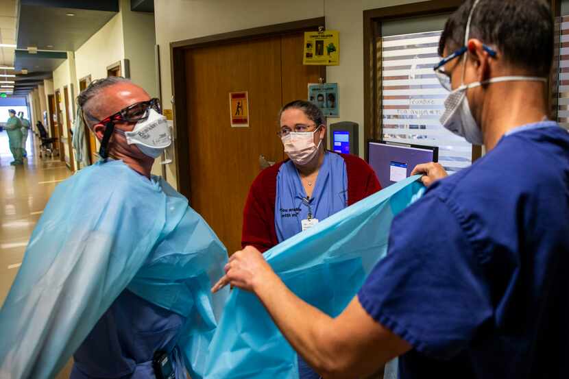 Health care workers such as these doctors and nurses in the COVID-19 intensive care unit at...