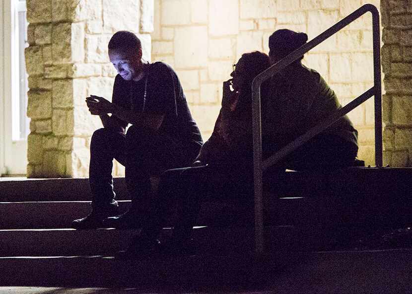  Jack in the Box employees sit on the steps of Whataburger after being evacuated while...