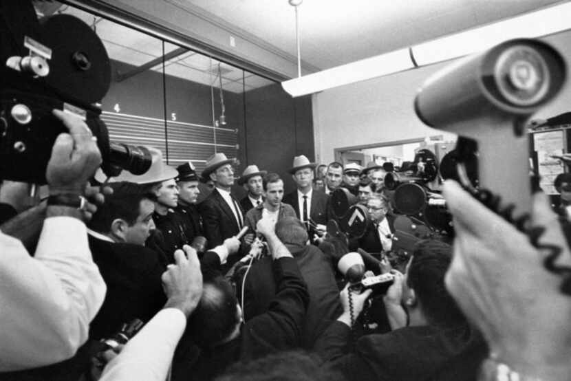 Lee Harvey Oswald is surrounded by media.